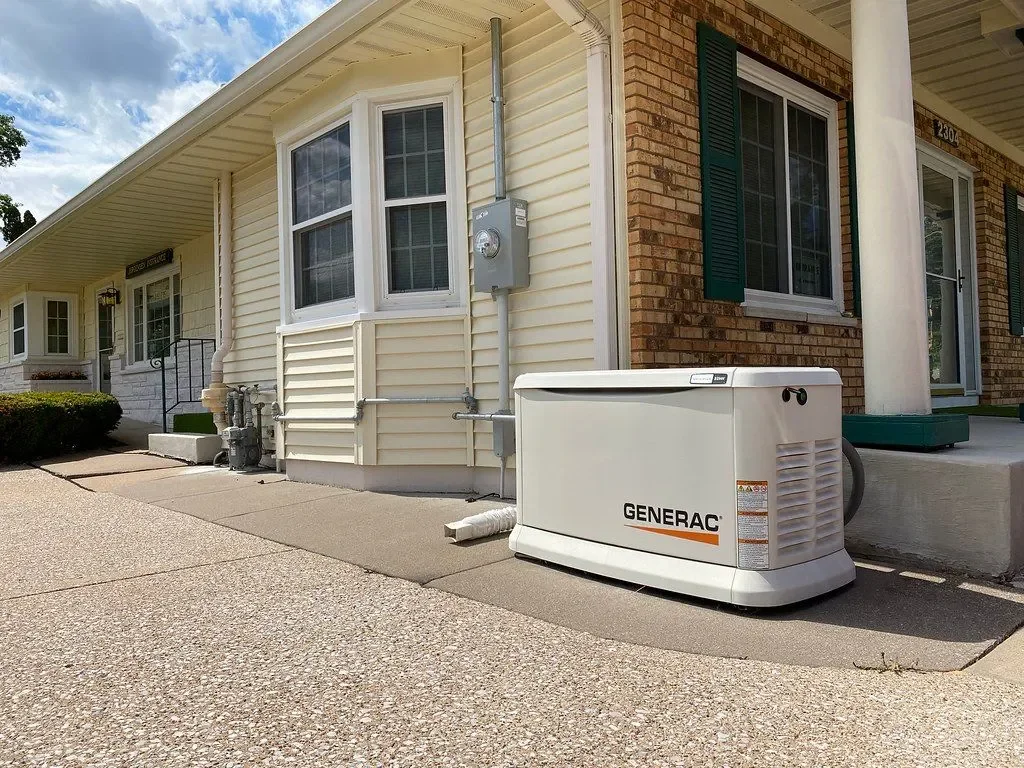 Compact Generac home standby generator installed beside a building; reference photograph, not a Bay Valley Electric project